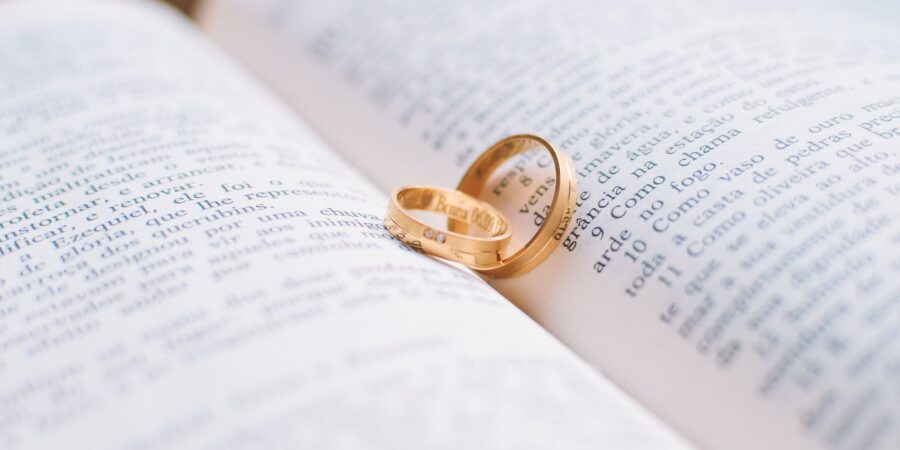 two gold colored wedding bands on book page