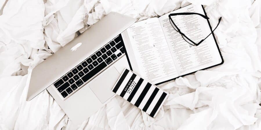 eyeglasses on book beside macbook