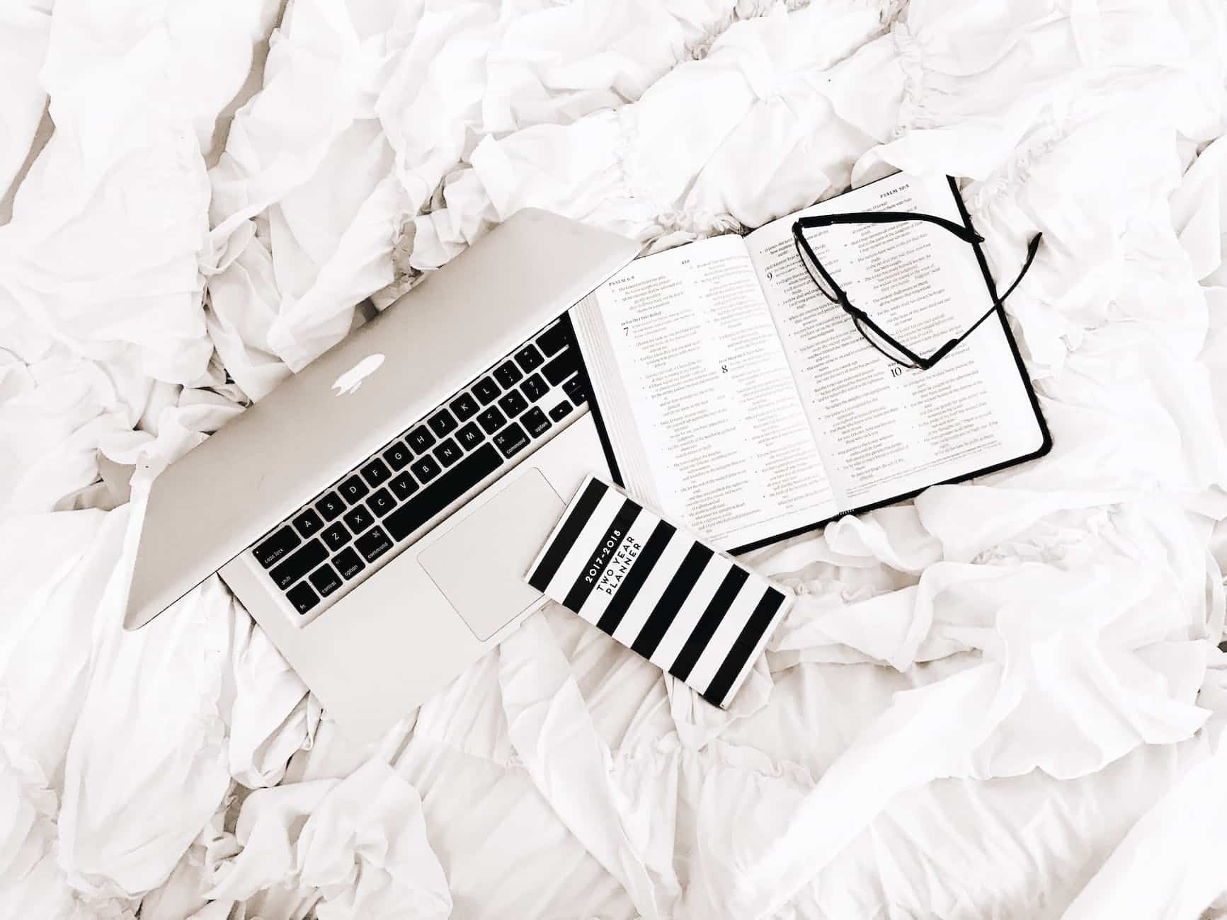 eyeglasses on book beside macbook